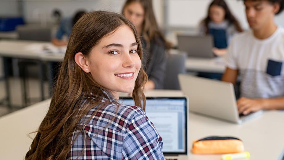 Ein Mädchen arbeitet mit einem Laptop im Klassenraum