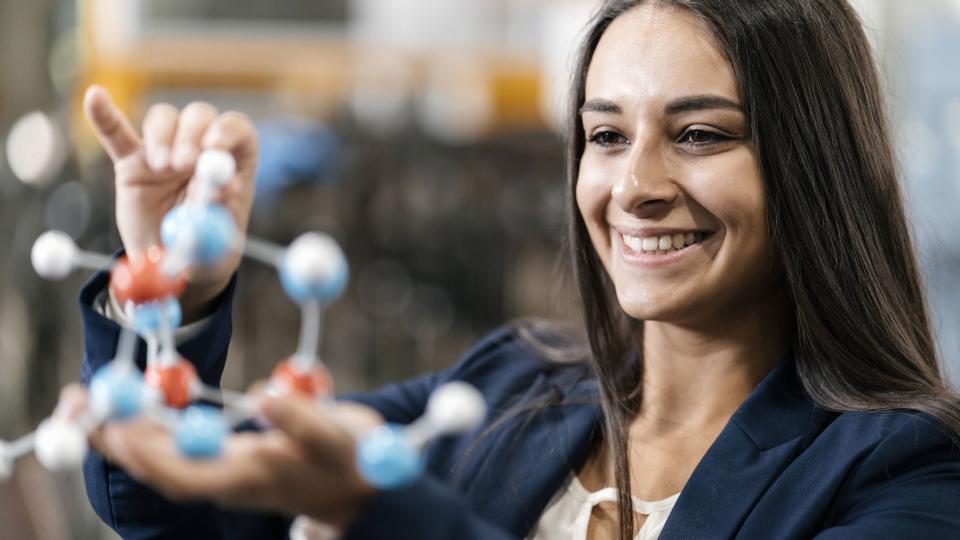 Eine Frau hält ein Modell eines Moleküls in der Hand