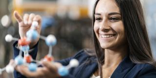 Eine Frau hält ein Modell eines Moleküls in der Hand